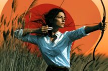 A woman with dark hair in a white shirt draws a bow in a grassy field, aiming an arrow. The background features tall grass and a vivid orange-red sun or circle in the sky.