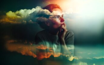 A woman gazes thoughtfully into the distance with her chin resting on her hand. Wispy, colorful clouds are superimposed over her, creating a dreamy, surreal atmosphere with soft light and vibrant hues.
