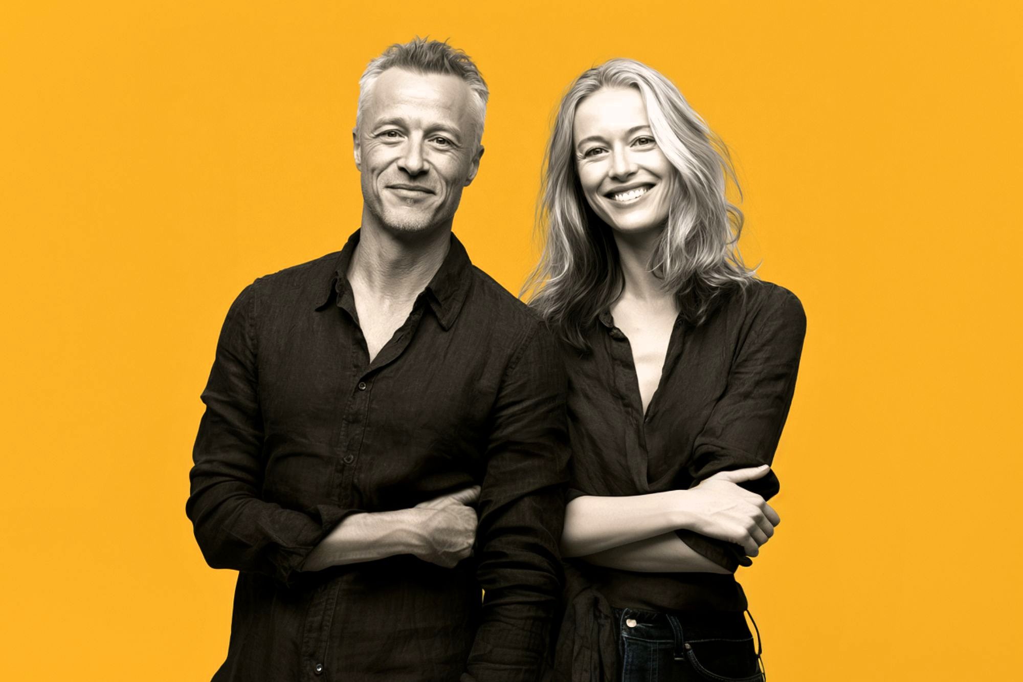A grayscale photo of a man and a woman standing side by side, both smiling and wearing dark shirts, with a bright yellow background.