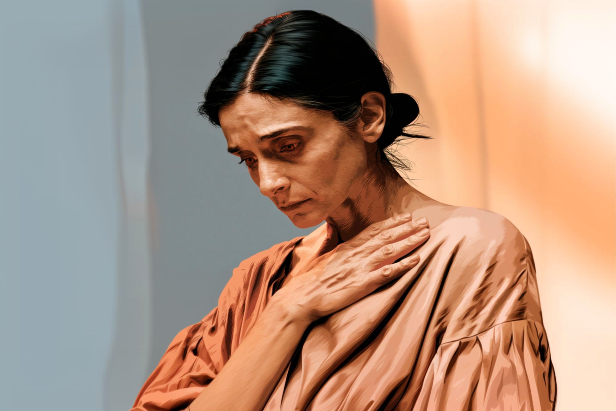 A woman with dark hair pulled back looks down sadly, her hand resting on her chest. She wears a loose, light brown top and stands against a softly lit, warm-toned background.