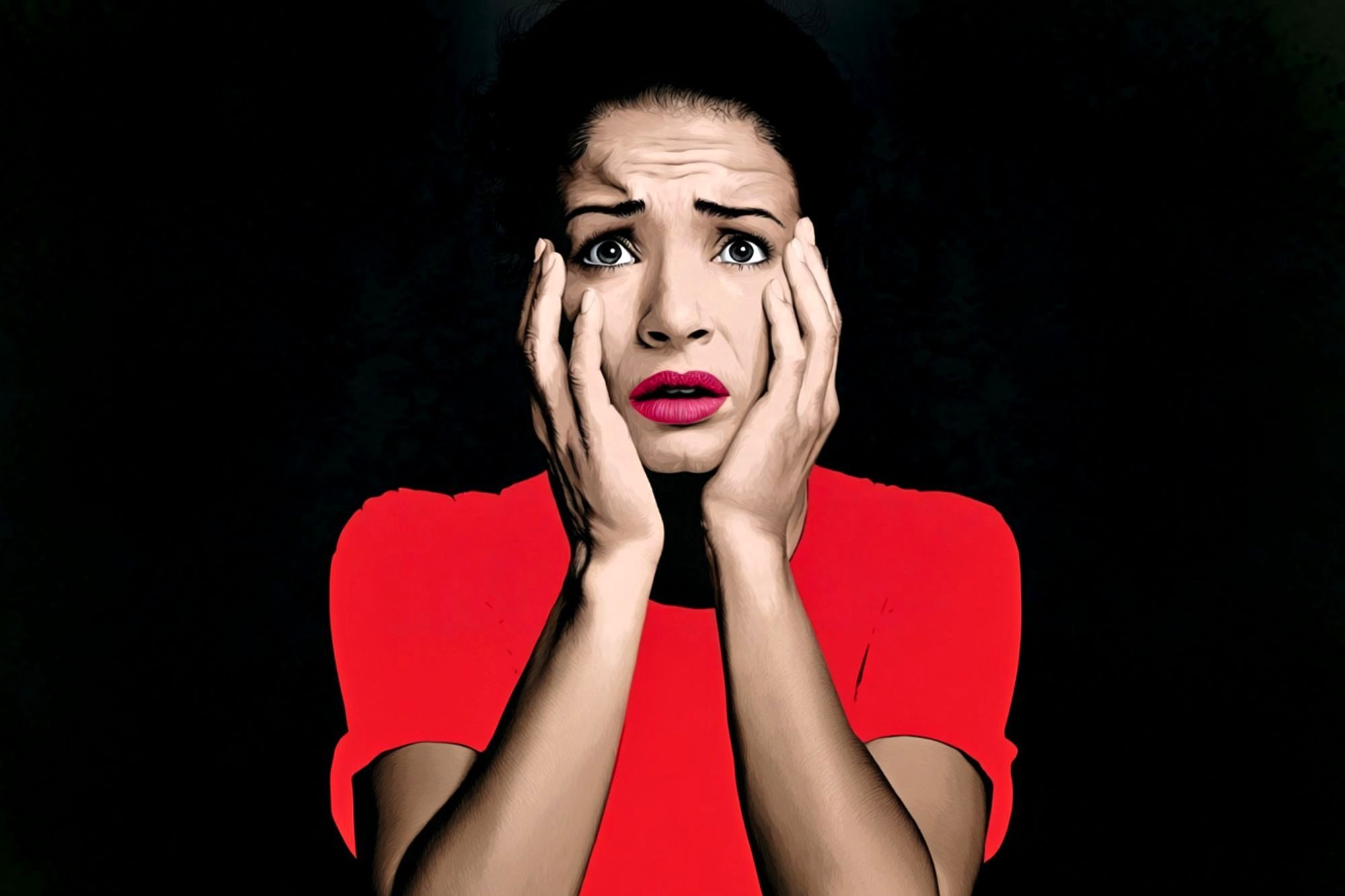 A woman in a bright red top holds her face in both hands, looking shocked or scared, with wide eyes and parted lips, set against a dark background.