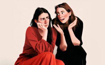 Two women sit together. One looks bored and rests her chin on her hand, wearing red. The other, in black, gestures energetically and smiles, appearing excited or enthusiastic. The background is plain and neutral.