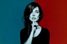 A woman with dark hair holds a finger to her lips, signaling silence. The background is split, blue on the left and red on the right.