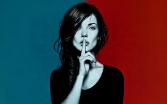 A woman with dark hair holds a finger to her lips, signaling silence. The background is split, blue on the left and red on the right.