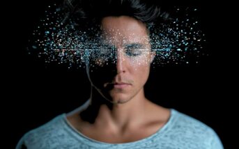 A person with closed eyes, surrounded by a cloud of glowing, digital-looking light particles emanating from their face.