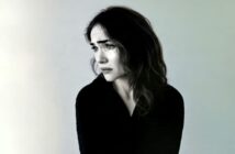 A woman looking away with a tearful, distressed expression.