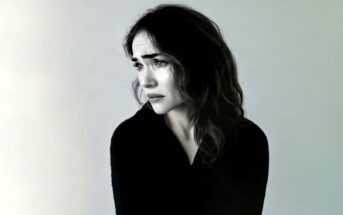A woman looking away with a tearful, distressed expression.