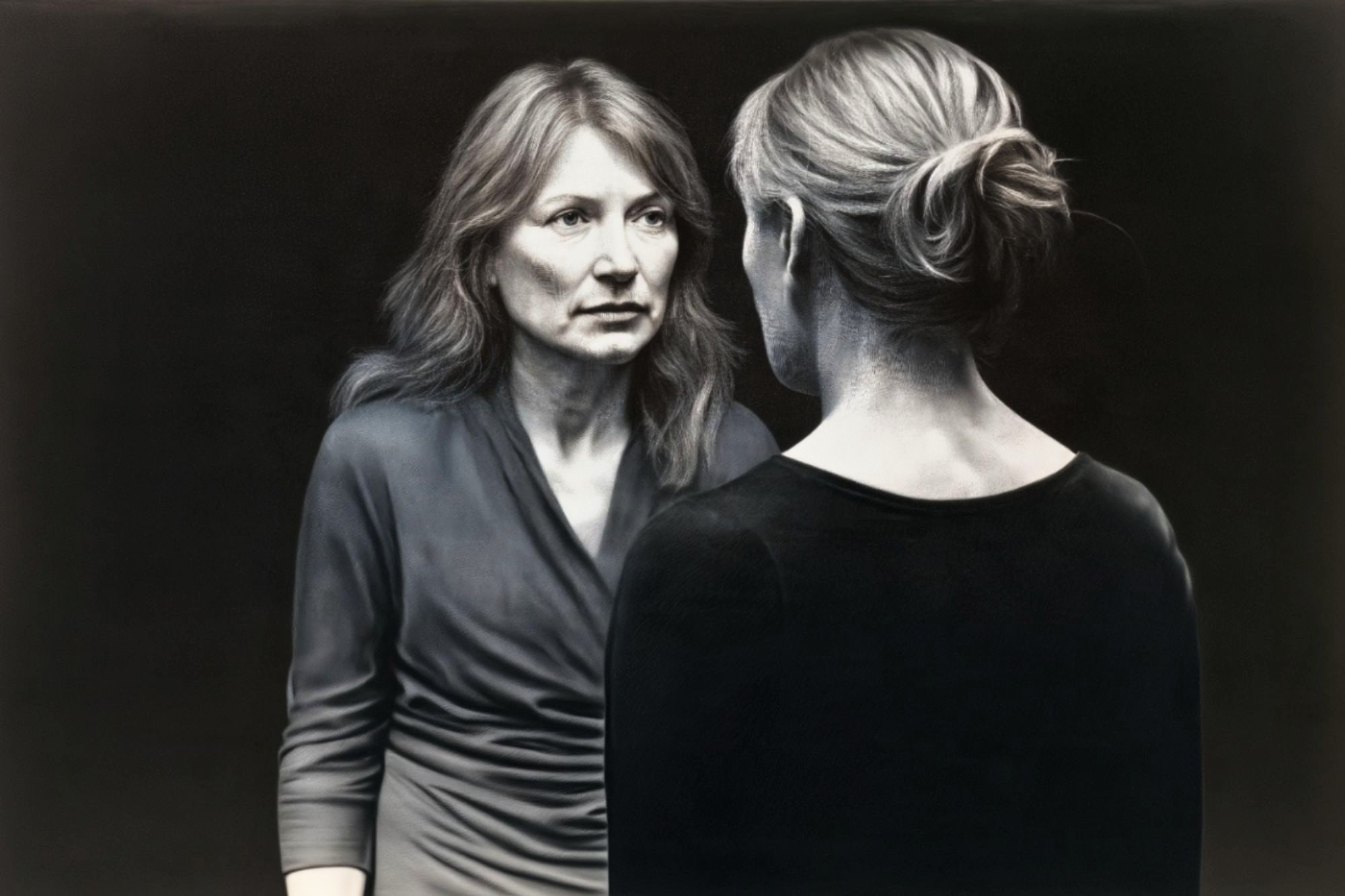 A woman with long hair looking at her own reflection in a mirror.