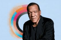 A man in a black jacket poses in front of a colorful circular pattern on a light blue background. The image has a digital, illustrated style.